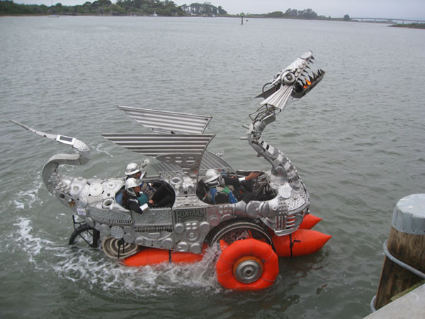 Reference: riders in a metal dragon-shaped kinetic vehicle on water
